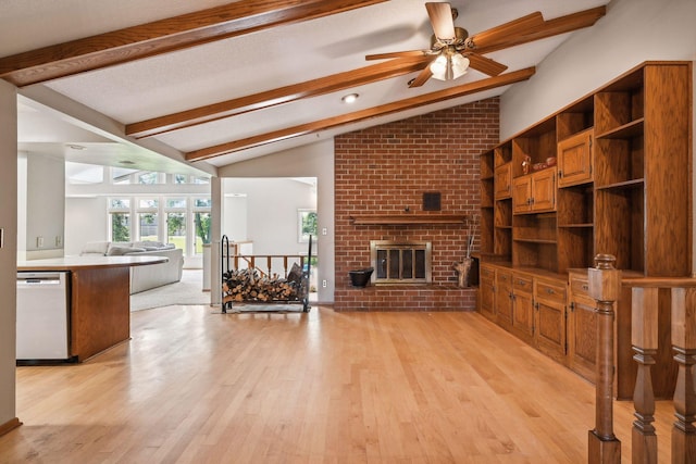 living area with vaulted ceiling with beams, light wood-style floors, a brick fireplace, and a ceiling fan