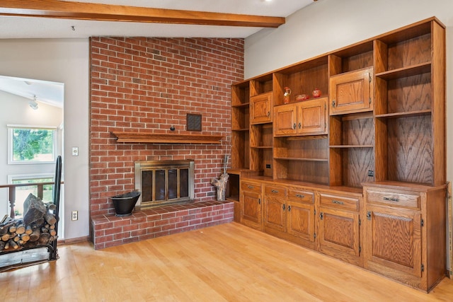 unfurnished living room featuring light wood-style flooring, a fireplace, lofted ceiling with beams, and baseboards