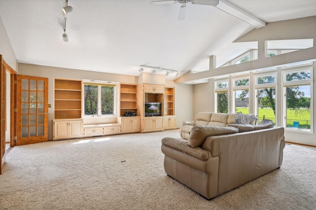 carpeted living room featuring vaulted ceiling with beams, rail lighting, and ceiling fan