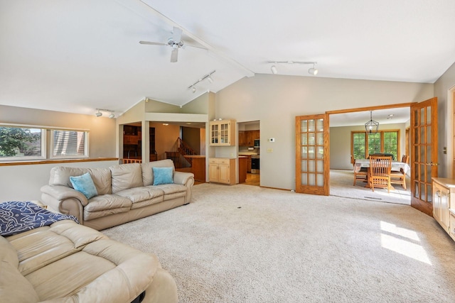 living room featuring french doors, a ceiling fan, light carpet, track lighting, and high vaulted ceiling