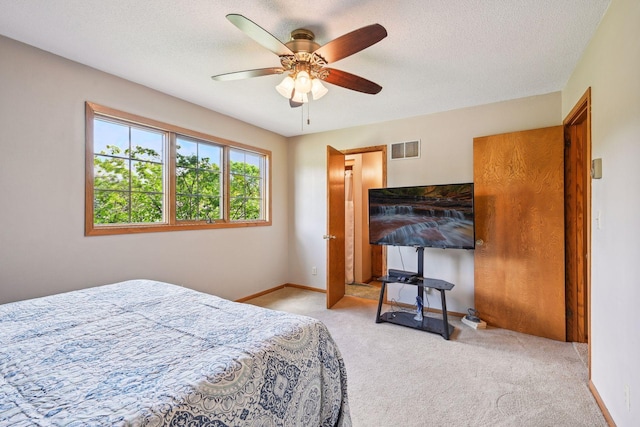 bedroom with a textured ceiling, carpet flooring, visible vents, and baseboards