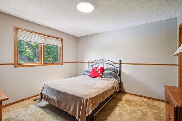 carpeted bedroom featuring a textured ceiling and baseboards