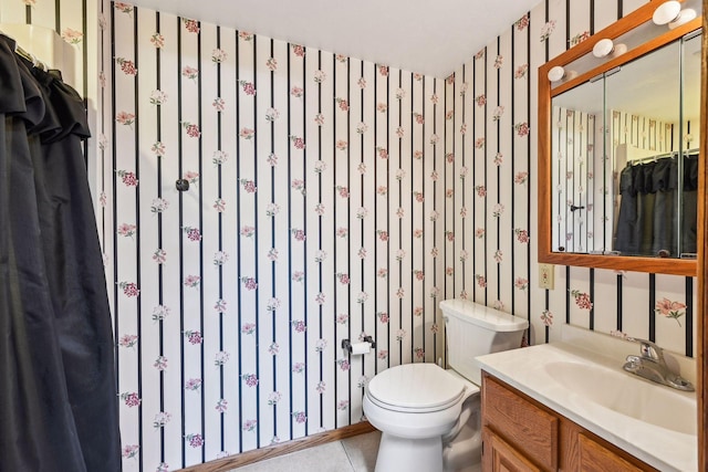 bathroom featuring tile patterned flooring, vanity, toilet, and wallpapered walls