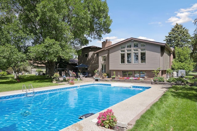 swimming pool featuring a lawn and a patio