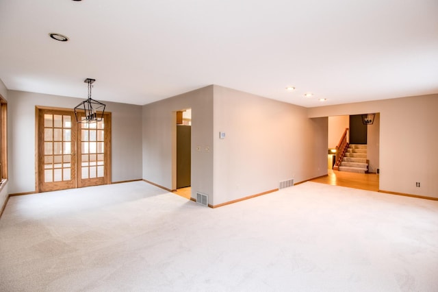 empty room with light carpet, stairs, baseboards, french doors, and recessed lighting