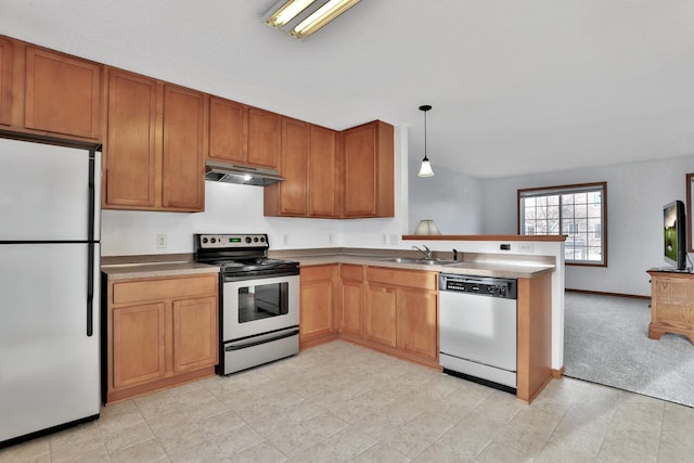 kitchen featuring a peninsula, a sink, hanging light fixtures, under cabinet range hood, and appliances with stainless steel finishes