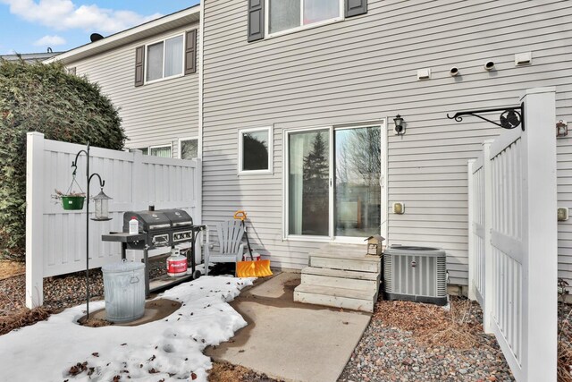 exterior space with entry steps, fence, central AC, and grilling area