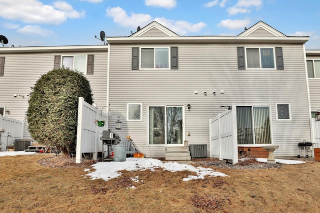 back of property with fence, central AC, a lawn, and entry steps