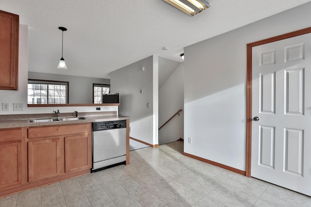 kitchen with a sink, stainless steel dishwasher, brown cabinetry, and hanging light fixtures