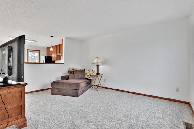 living area with visible vents, baseboards, carpet, and a textured ceiling