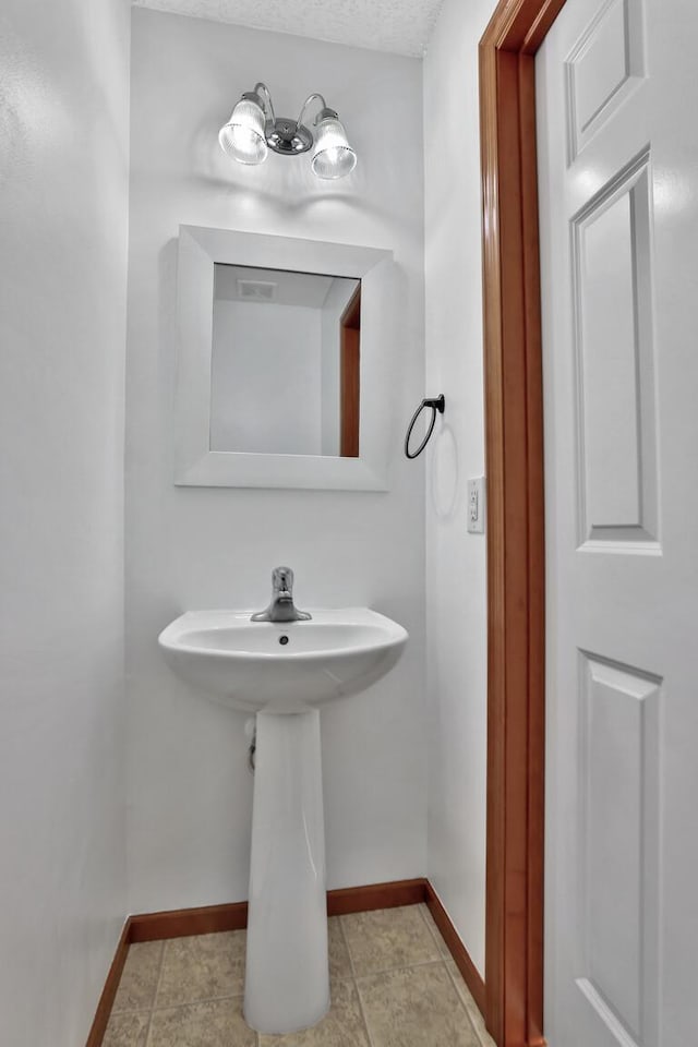 bathroom with baseboards and a sink