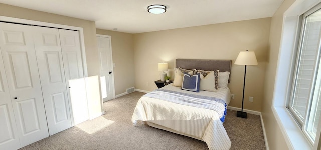 carpeted bedroom featuring visible vents, baseboards, and a closet