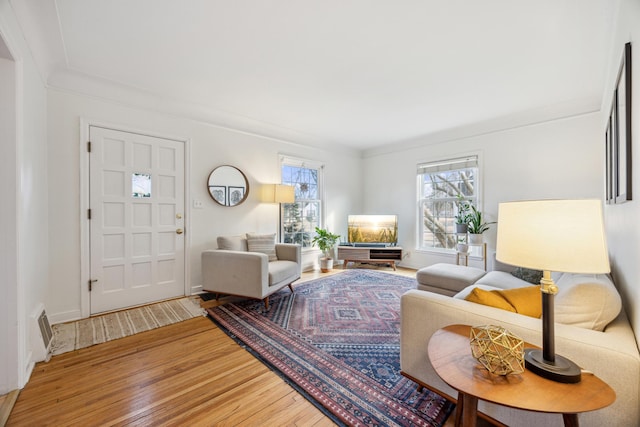 living area with visible vents, light wood-style flooring, and baseboards