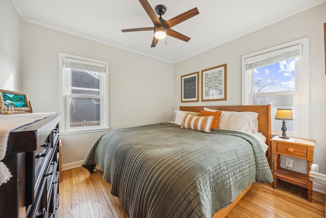 bedroom with ornamental molding, baseboards, and light wood finished floors