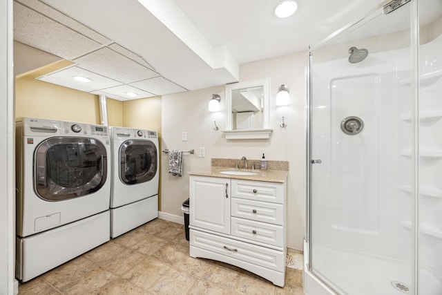 washroom with baseboards, laundry area, a sink, and washer and dryer