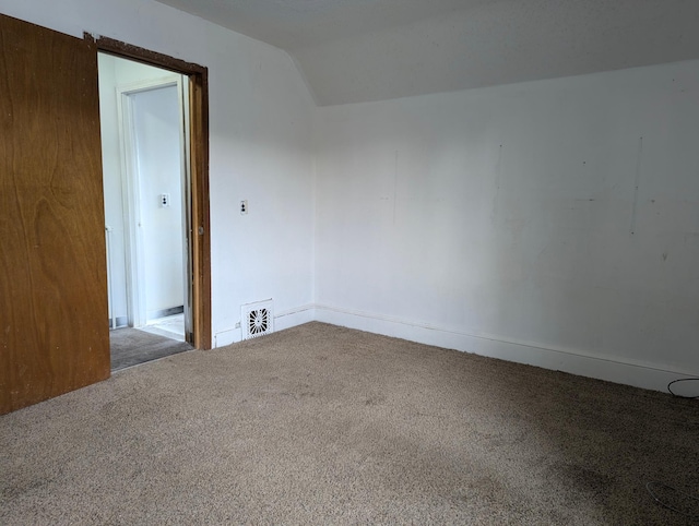 spare room featuring lofted ceiling and carpet floors