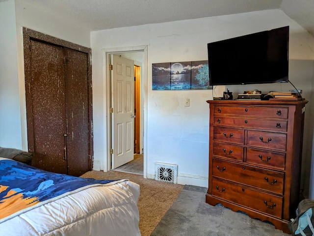 carpeted bedroom with visible vents and a closet