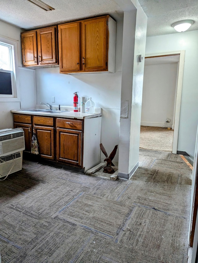 kitchen featuring light countertops, carpet, a wall mounted air conditioner, and a textured ceiling