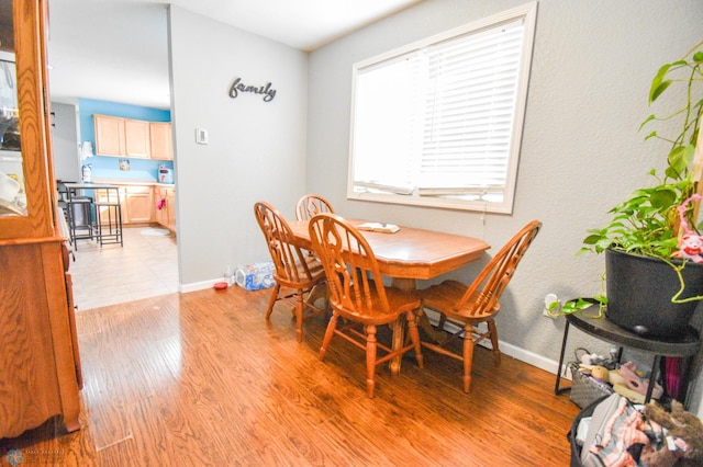 dining space with light wood-style flooring and baseboards