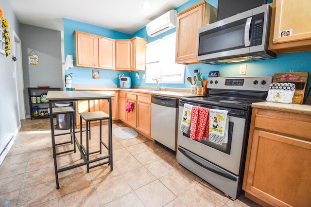 kitchen with light brown cabinets, stainless steel appliances, a sink, an AC wall unit, and light countertops