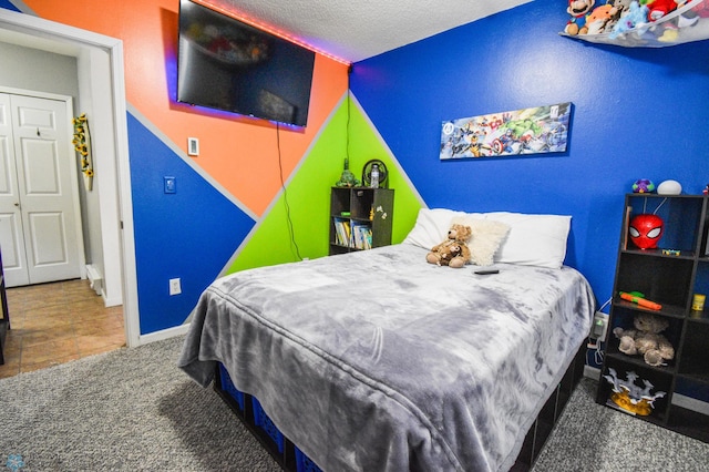 carpeted bedroom with baseboards and a textured ceiling