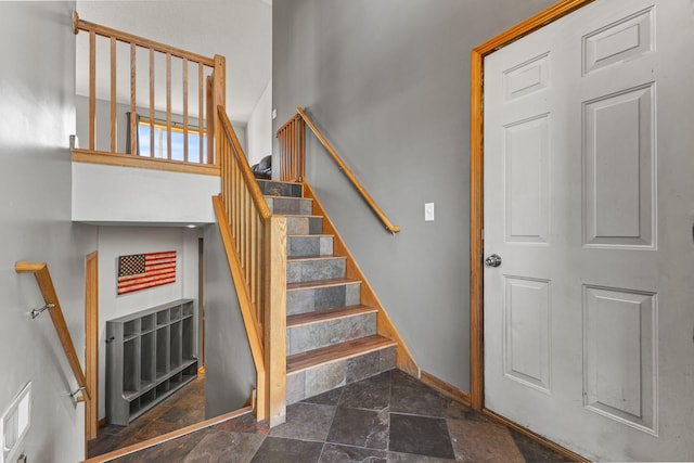 stairs with baseboards and stone tile flooring