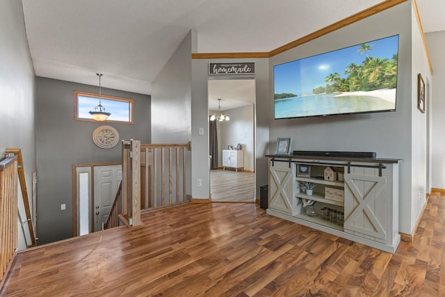 interior space featuring baseboards, a high ceiling, wood finished floors, and a notable chandelier