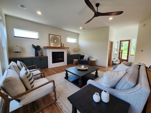 living area featuring a fireplace, recessed lighting, visible vents, ceiling fan, and light wood-type flooring