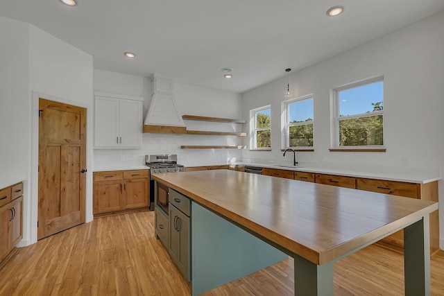 6624 Captains Cir NW, Sauk Rapids, MN 56379 - kitchen featuring stainless steel range with gas cooktop, a sink, open shelves, butcher block counters, and light wood finished floors