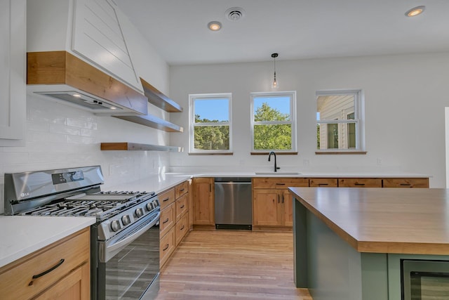 6624 Captains Cir NW, Sauk Rapids, MN 56379 - kitchen with appliances with stainless steel finishes, a sink, decorative backsplash, light countertops, and light wood-type flooring