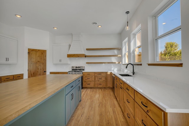 6624 Captains Cir NW, Sauk Rapids, MN 56379 - kitchen with a sink, custom exhaust hood, stainless steel range, white cabinets, and open shelves