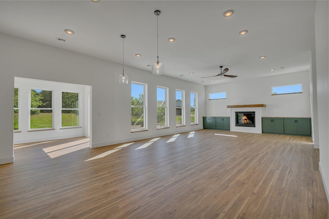6624 Captains Cir NW, Sauk Rapids, MN 56379 - unfurnished living room featuring healthy amount of natural light, recessed lighting, a ceiling fan, a glass covered fireplace, and wood finished floors