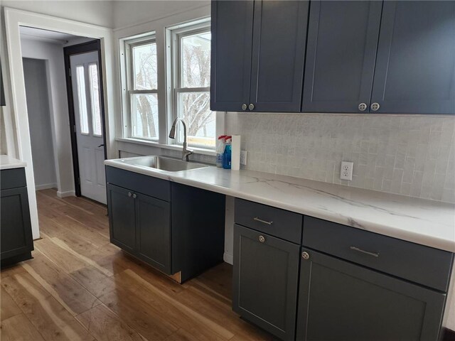 kitchen featuring tasteful backsplash, a sink, and light wood-style floors