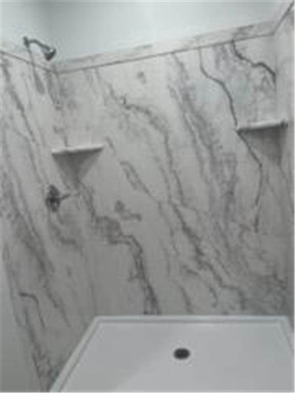 room details featuring a marble finish shower