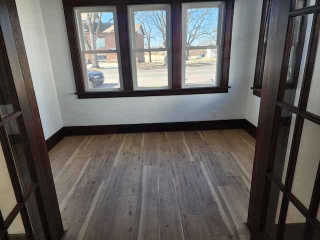 unfurnished room with wood-type flooring and baseboards