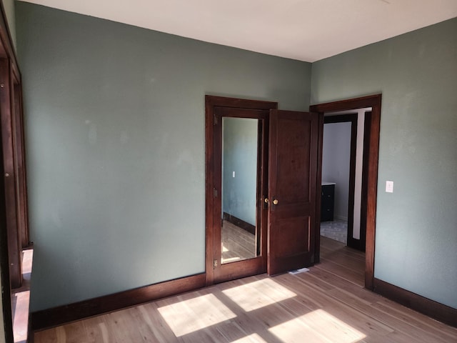 empty room with baseboards and wood finished floors