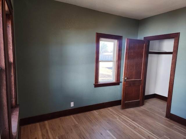 unfurnished bedroom featuring baseboards and wood finished floors