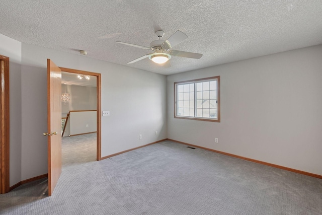 unfurnished bedroom featuring a ceiling fan, light carpet, a textured ceiling, and baseboards