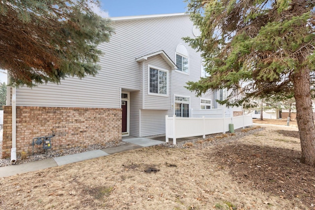 view of front of property with brick siding and fence