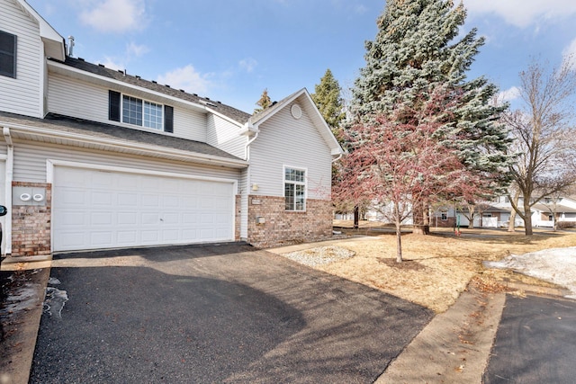 view of front of house with driveway and brick siding