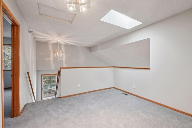 carpeted empty room with a textured ceiling, visible vents, and baseboards