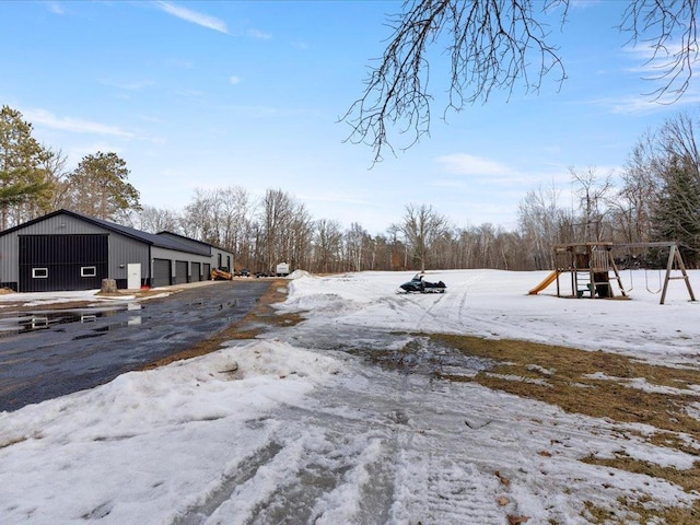 yard covered in snow with a playground and a garage