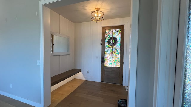 entrance foyer with an inviting chandelier, baseboards, and wood finished floors