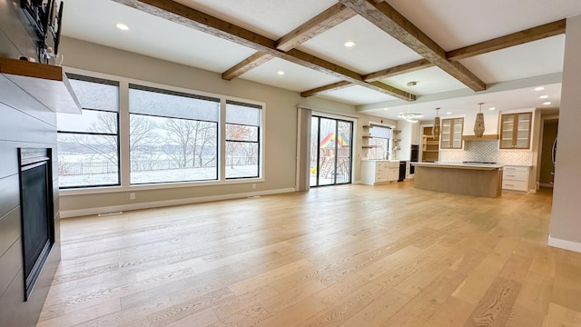 interior space with baseboards, coffered ceiling, light wood-style flooring, beam ceiling, and recessed lighting