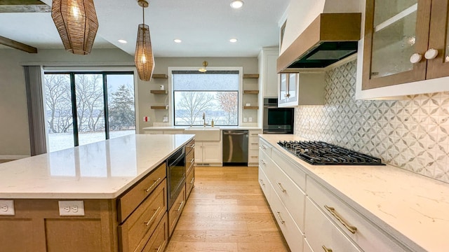 kitchen with decorative backsplash, appliances with stainless steel finishes, light wood-style floors, open shelves, and exhaust hood