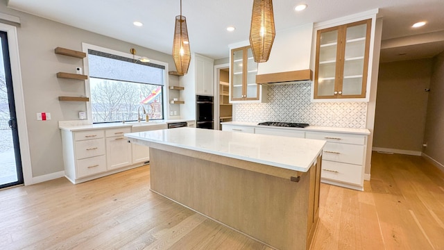 kitchen featuring gas stovetop, white cabinets, light wood-type flooring, backsplash, and open shelves