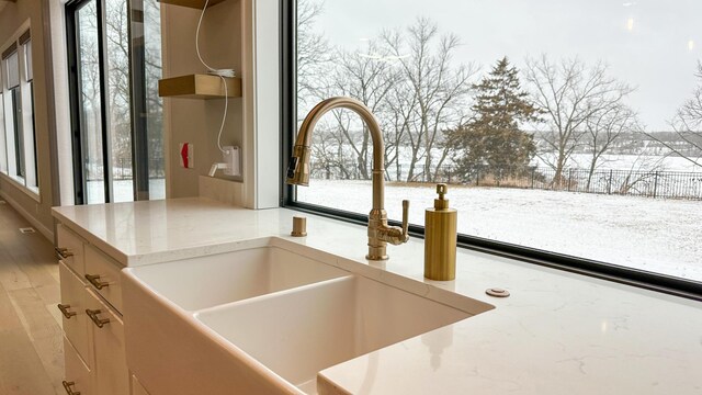 interior details with a sink and light stone countertops