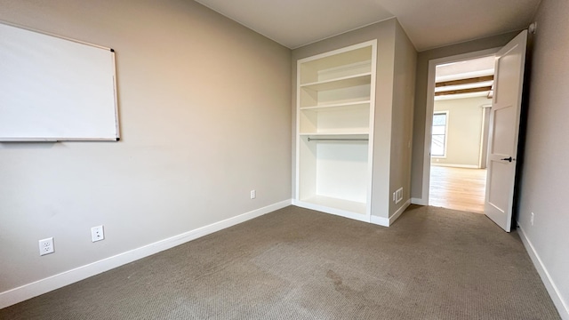 unfurnished bedroom featuring dark carpet and baseboards