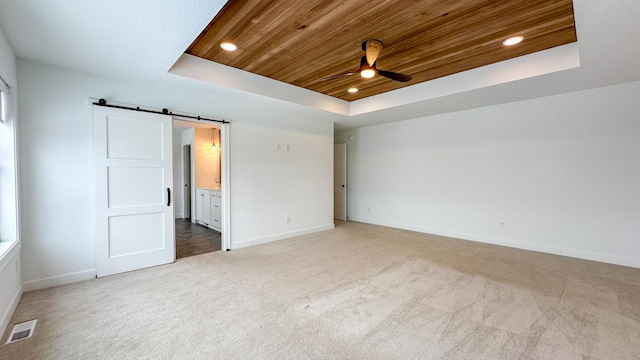 unfurnished bedroom featuring a barn door, visible vents, a raised ceiling, wood ceiling, and recessed lighting