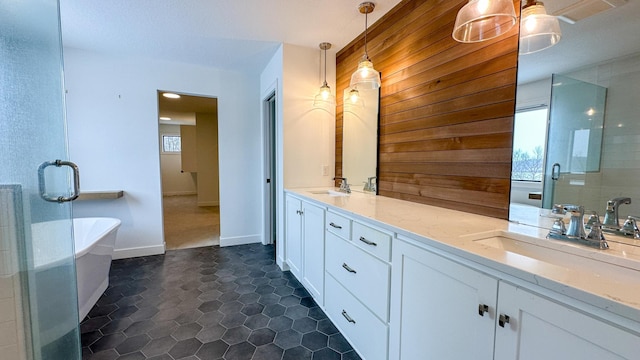 full bathroom featuring double vanity, a shower stall, a freestanding bath, and a sink